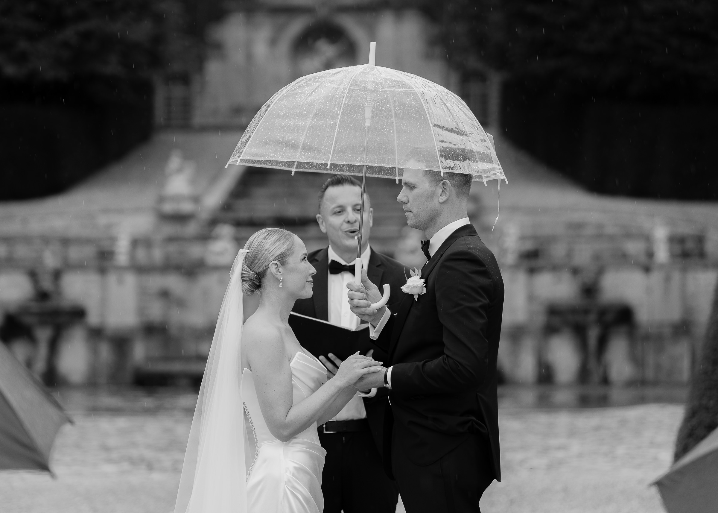 Couple saying vows beneath umbrellas during Château Villette wedding ceremony in the rain