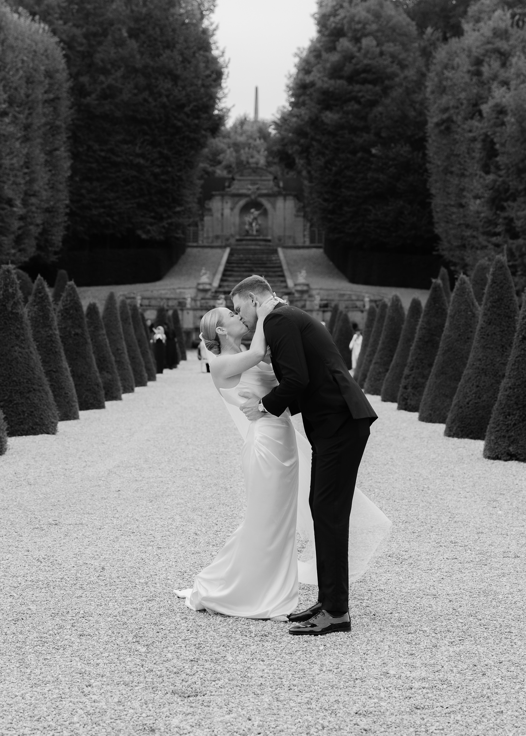 Bride and groom kissing in the Château Villette’s French gardens