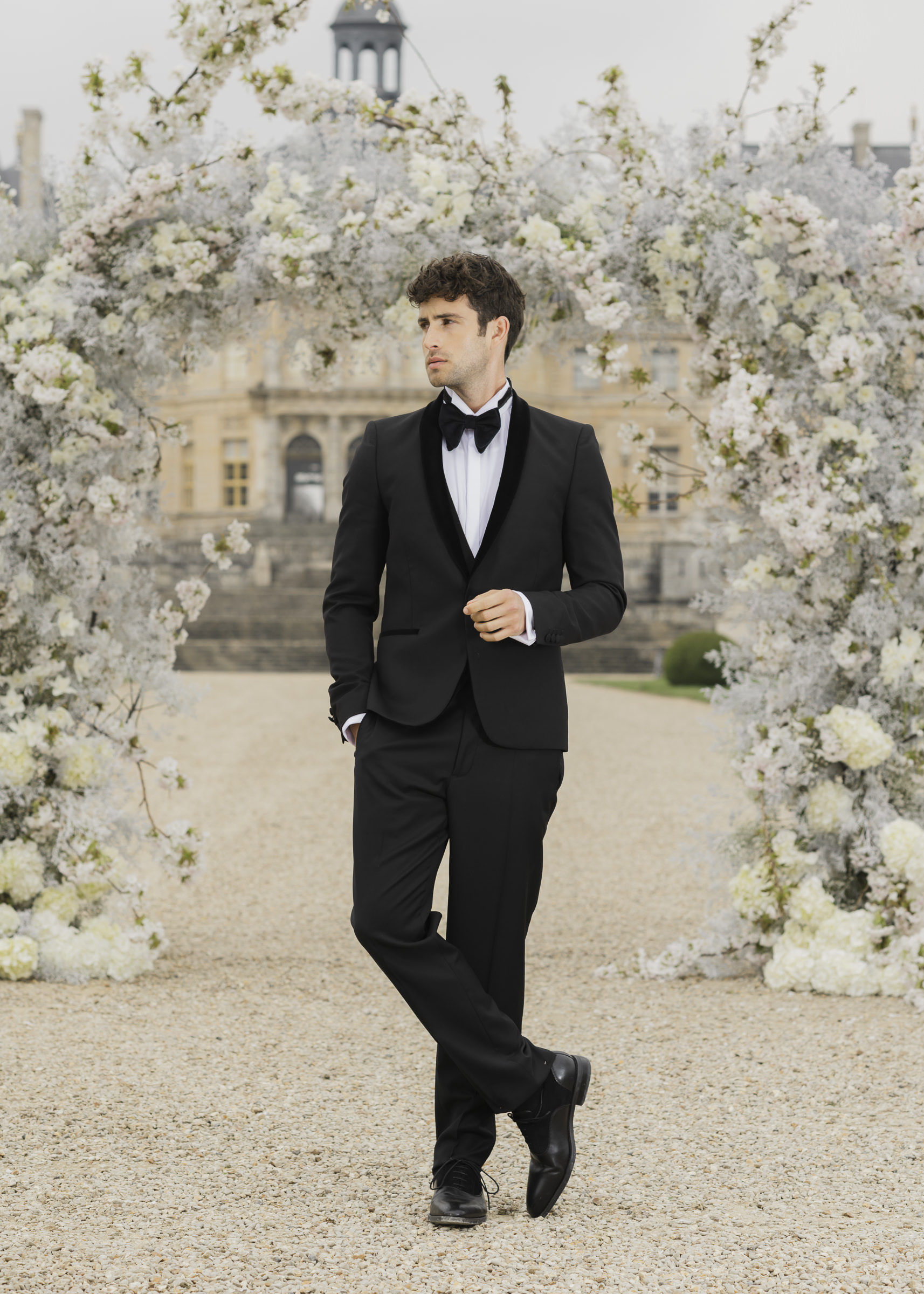 Luxury groom portrait framed by florals at Château de Vaux-le-Vicomte