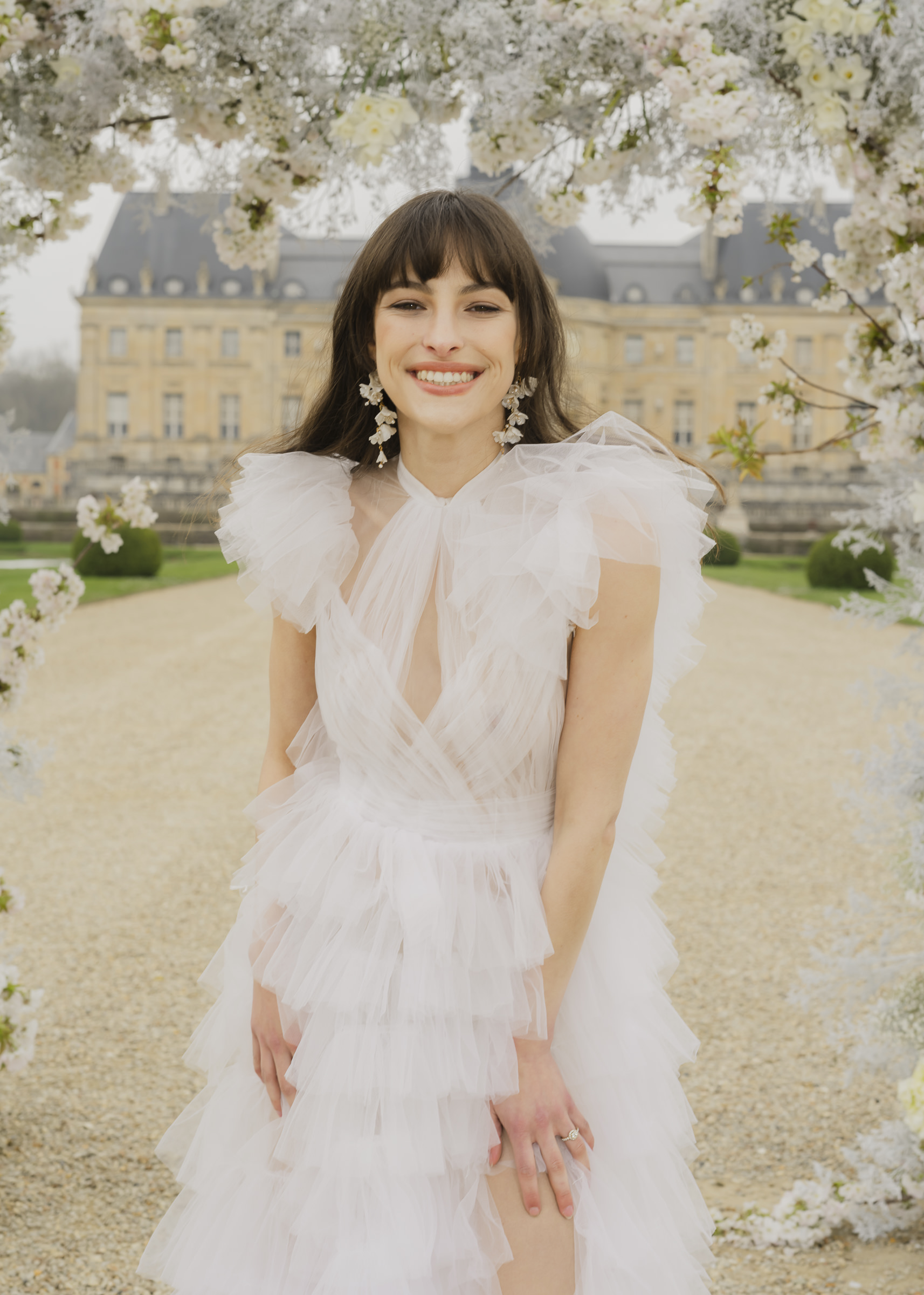 Editorial bride wedding portrait framed by monochromatic florals in a French château