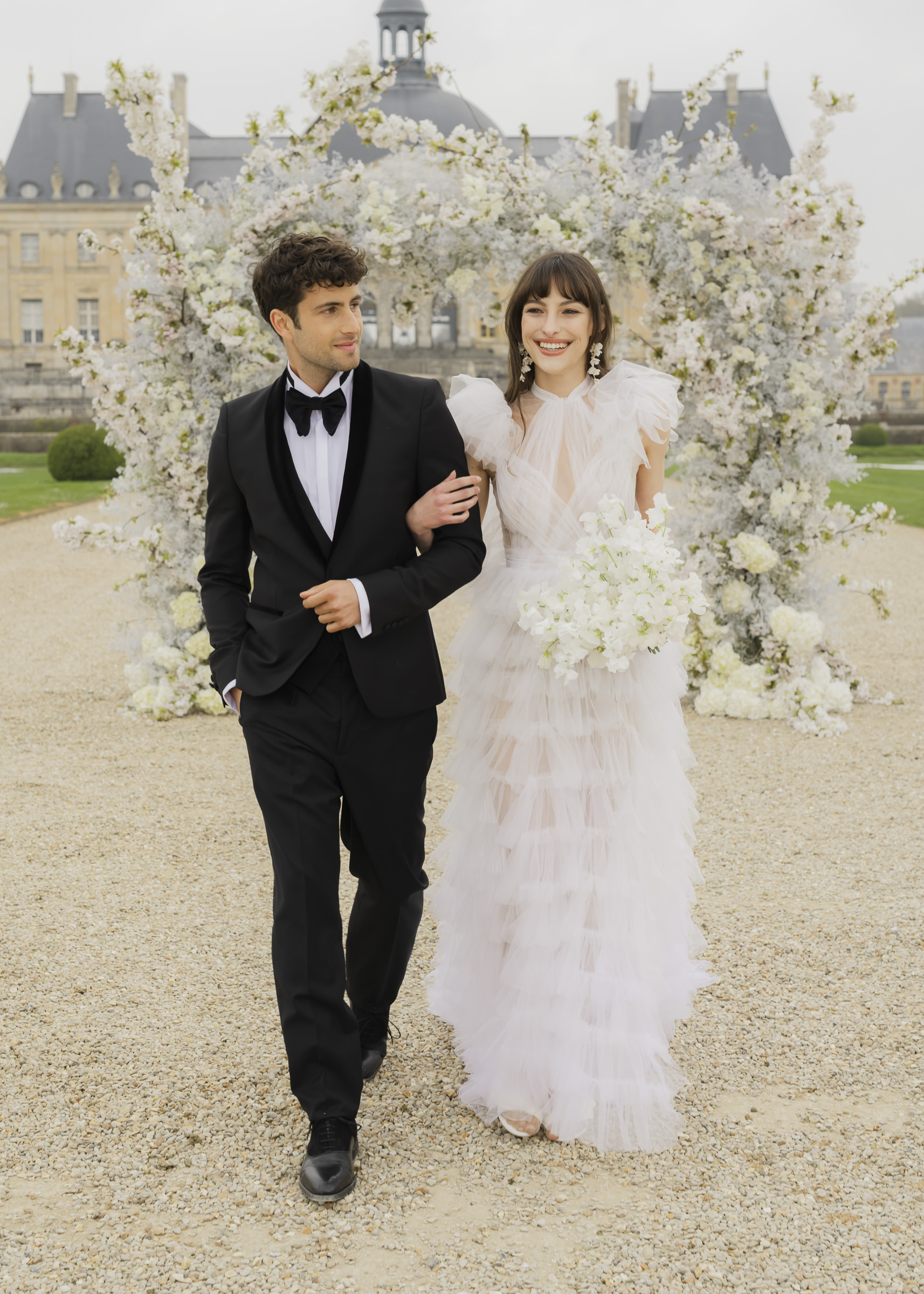 Bride and groom walking away together after their french château wedding ceremony
