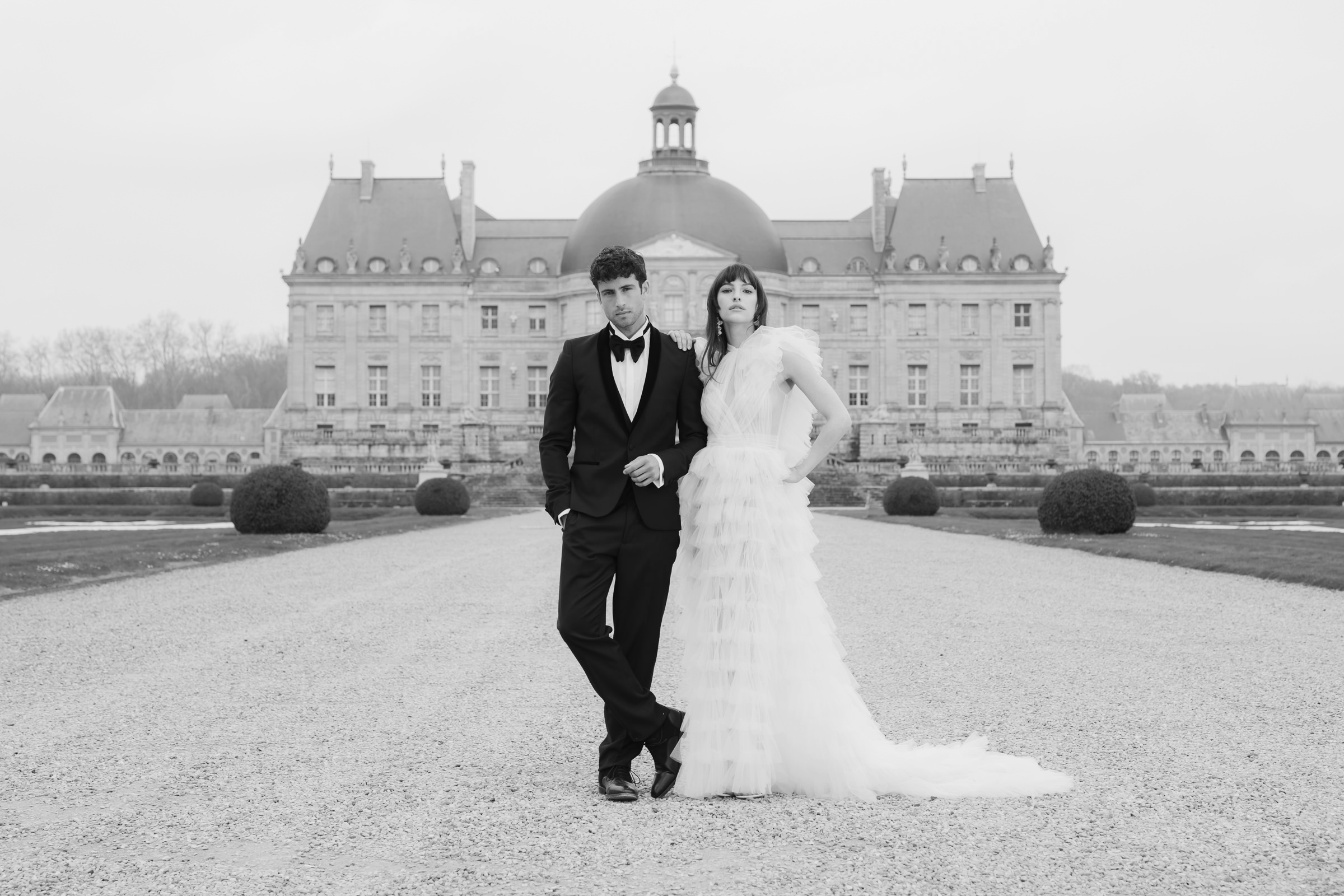 Fashion-inspired wedding portrait of bride and groom in the gardens of a French château