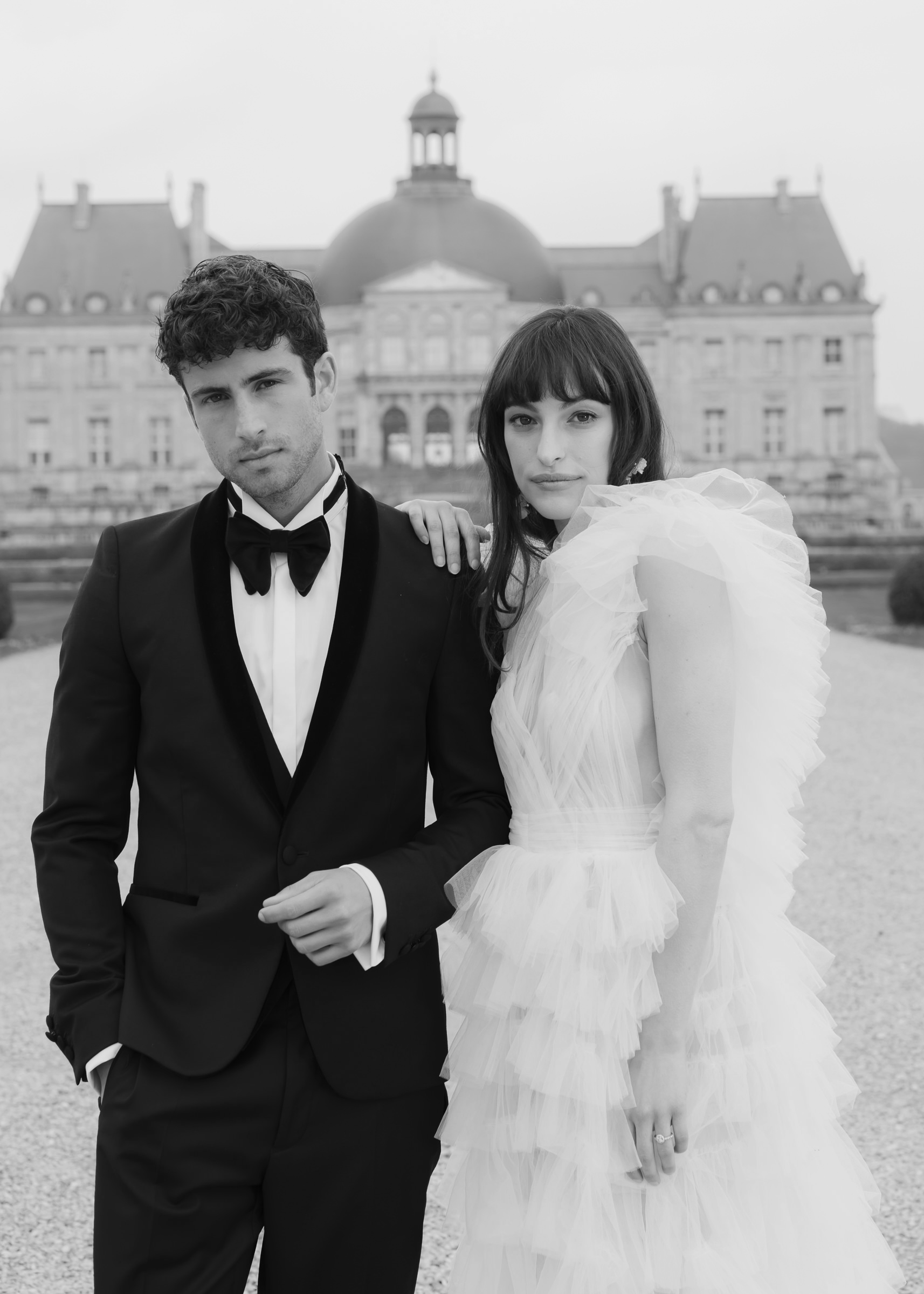 Bride and groom posing elegantly in the gardens of Château de Vaux-le-Vicomte
