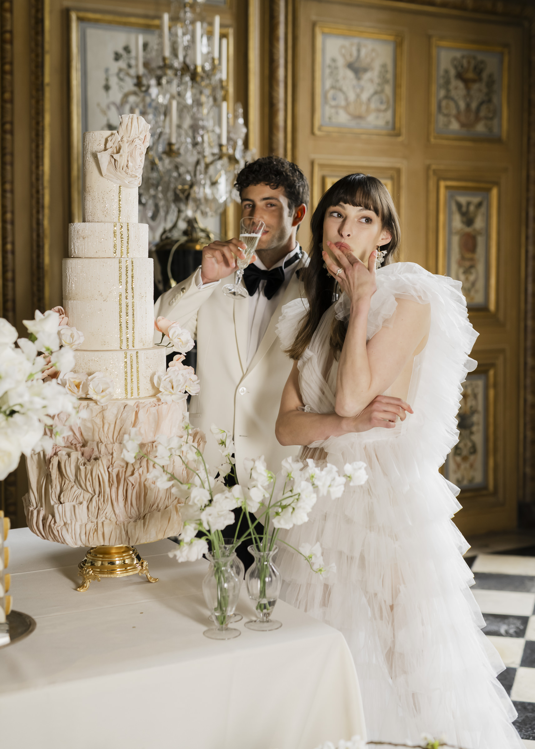 Bride and groom cutting their wedding cake at luxurious french chateau
